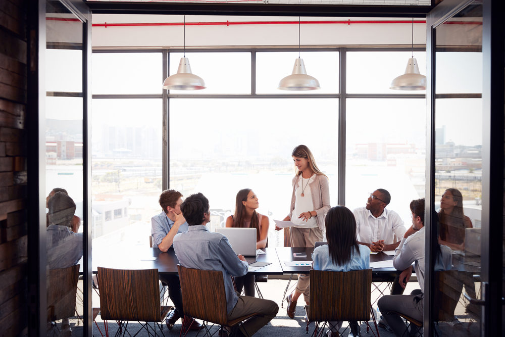 Woman standing at a meeting in a business boardroom